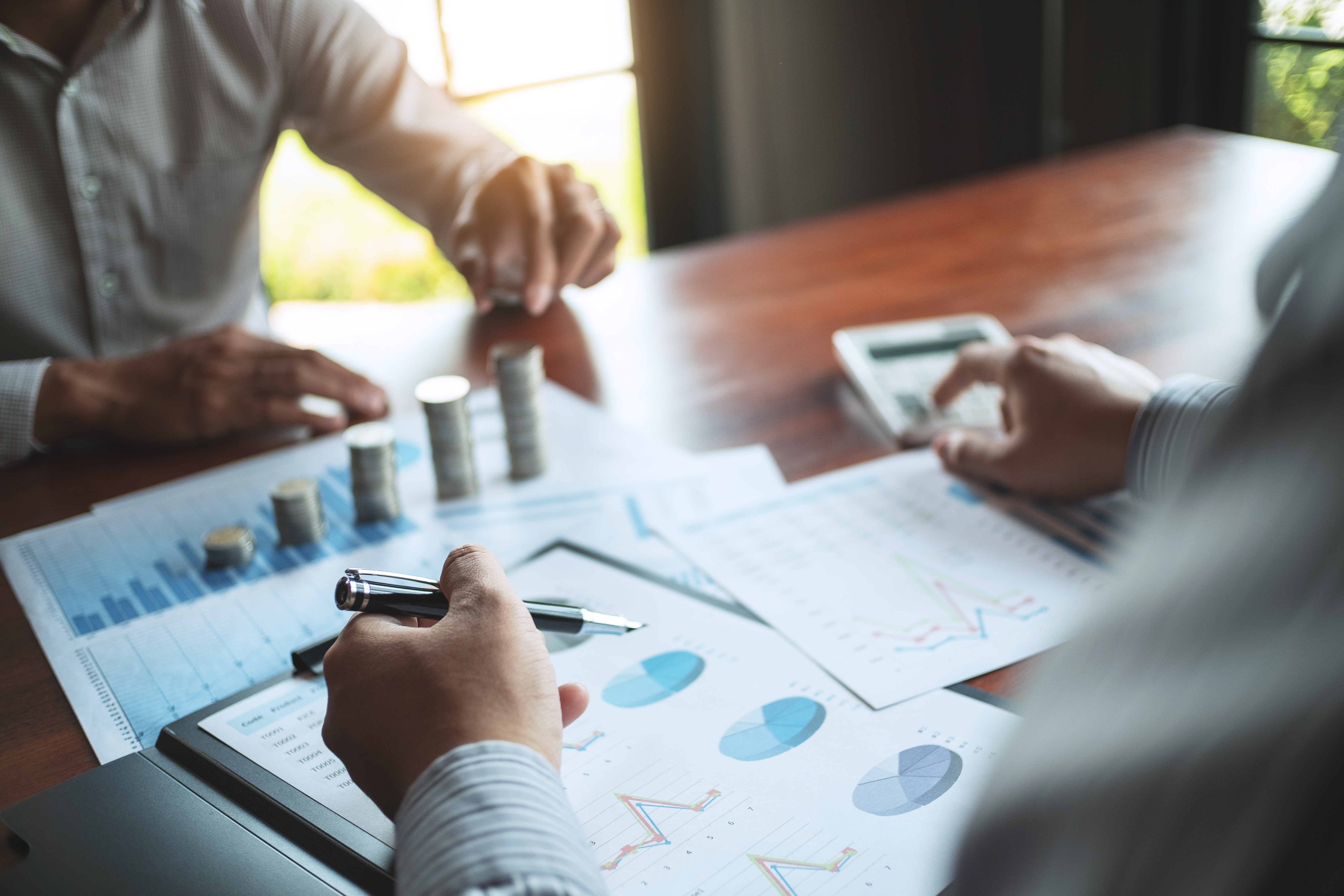 Business professional reviewing financial documents and growth charts representing financial planning for business owners and personal wealth development.