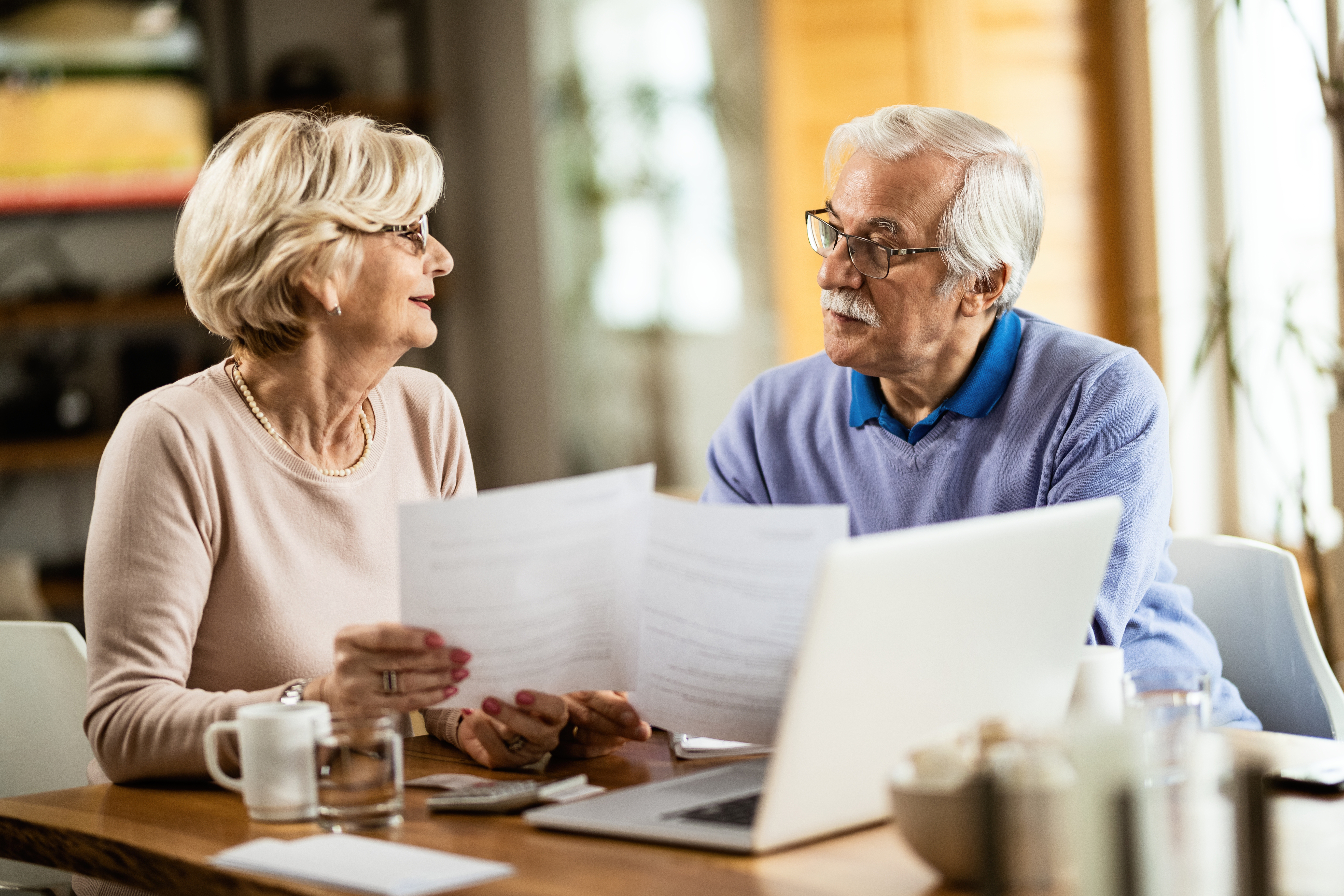 Couple reviewing financial documents and retirement savings plans representing retirement income planning for a comfortable retirement in the UK.