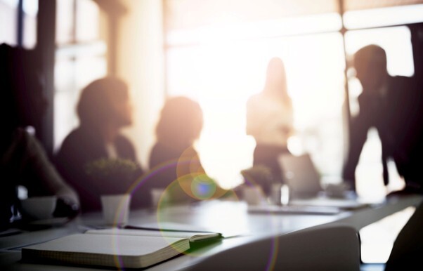 Business owners in a meeting discussing financial arrangements and what a shareholder protection policy could mean for their company.